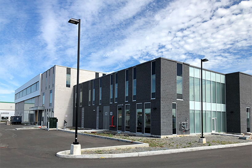 Bâtiment industriel et commercial moderne en béton avec grandes fenêtres verticales