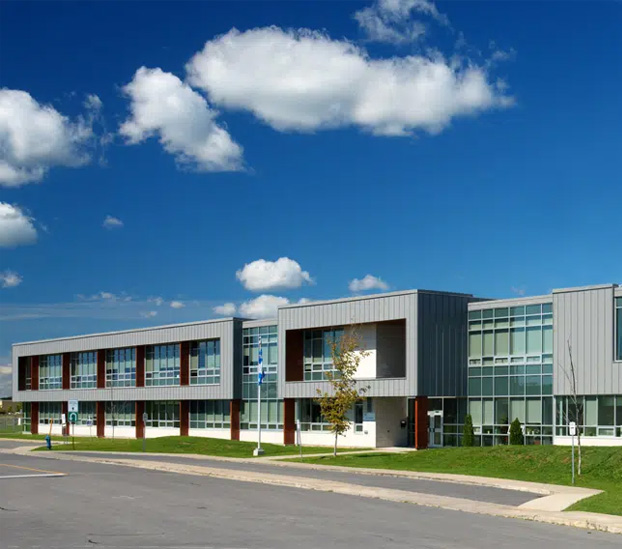 Bâtiment institutionnel moderne à structure de béton, revêtement métallique et grandes fenêtres
