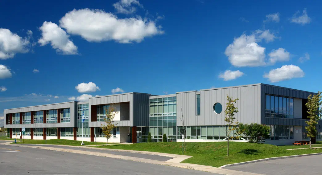 Bâtiment institutionnel moderne à structure de béton, revêtement métallique et grandes fenêtres